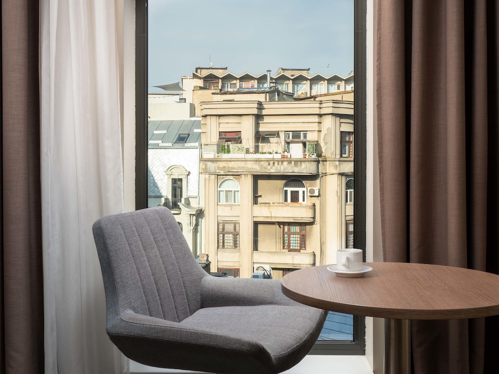 Suite Privilege con 1 cama doble y sofá del hotel Mercure Bucharest City Center. Foto 5