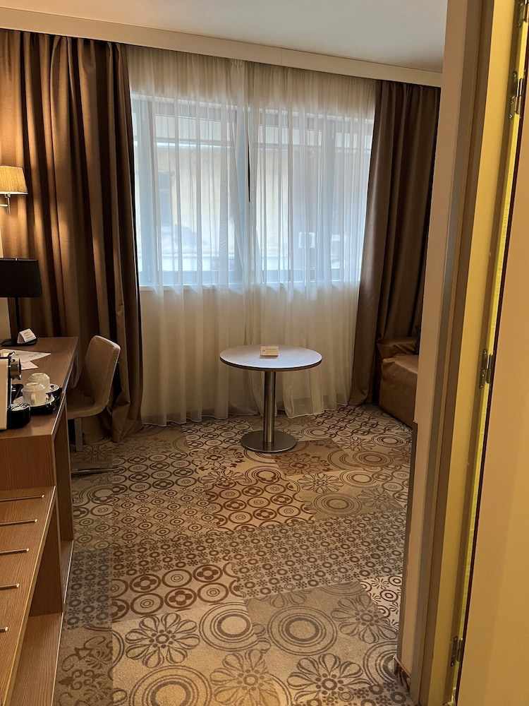 Suite Privilege con 1 cama doble y sofá del hotel Mercure Bucharest City Center. Foto 11