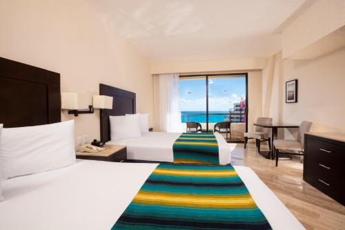Habitación Doble con cama grande y vistas al mar del hotel Crown Paradise Club Cancun All Inclusive. Foto 1