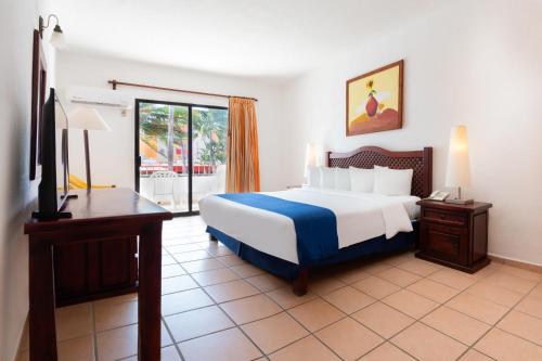 Habitación con cama extragrande y vistas al mar del hotel Grand Decameron Complex Bucerias, A Trademark All-Inclusive Resort. Foto 5