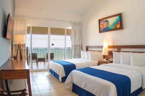 Habitación Doble con vistas al océano - 2 camas dobles del hotel Grand Decameron Complex Bucerias, A Trademark All-Inclusive Resort. Foto 1