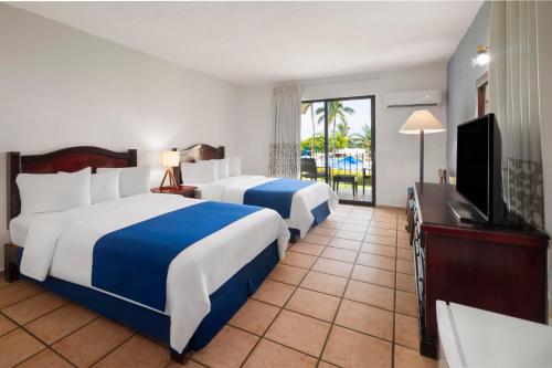 Habitación Doble Estándar con 2 camas dobles del hotel Grand Decameron Complex Bucerias, A Trademark All-Inclusive Resort. Foto 1