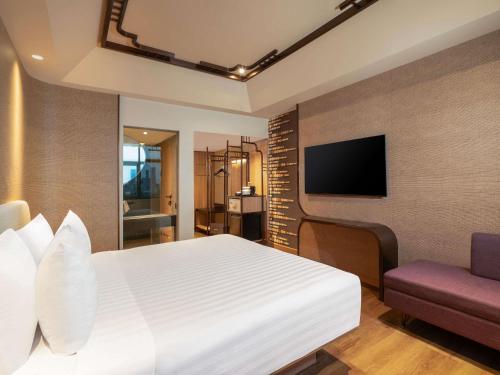 Habitación Privilege con cama extragrande y vistas a la ciudad del hotel Mercure Surabaya Grand Mirama. Foto 1
