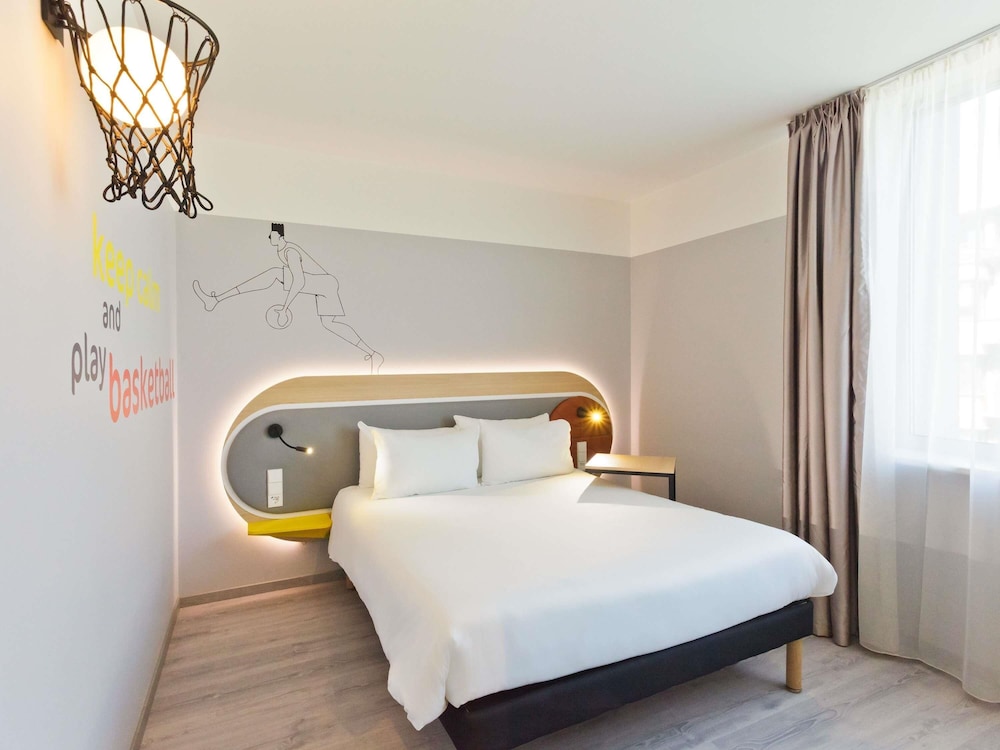 Habitación con una cama doble queen size y un sofá cama individual del hotel Ibis Styles Kaunas Centre. Foto 1