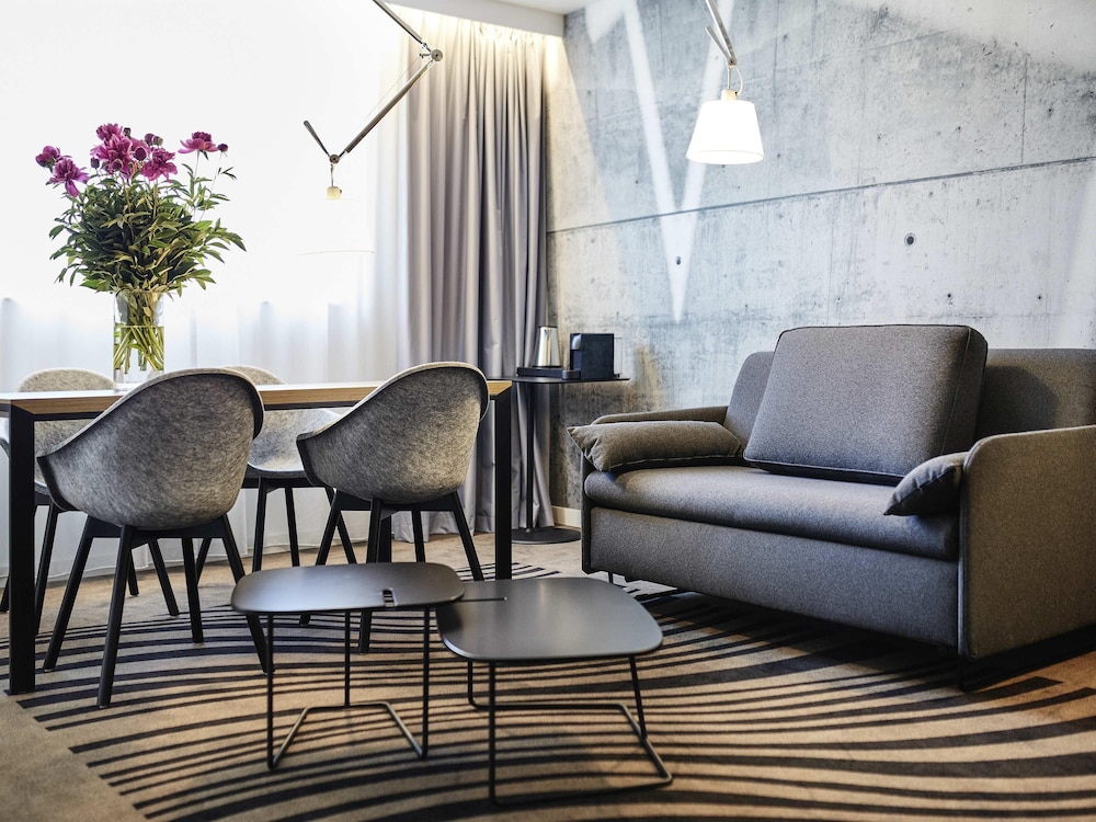 Suite Superior con cama grande, sofá y cocina del hotel Novotel Krakow City West