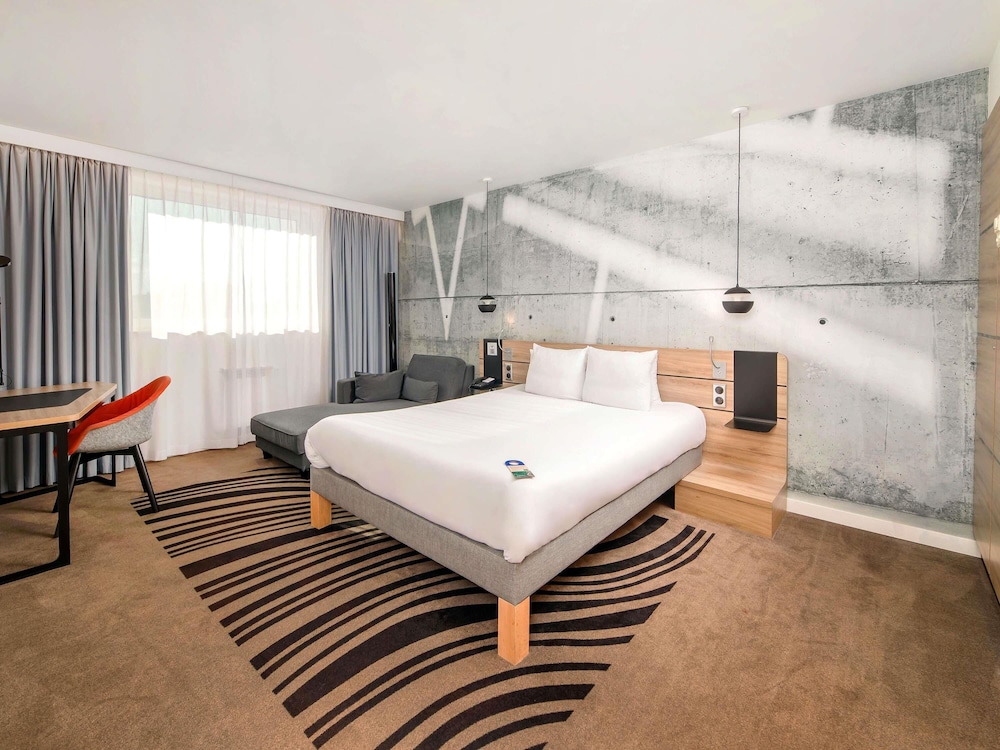 Suite Superior con cama grande, sofá y cocina del hotel Novotel Krakow City West. Foto 1