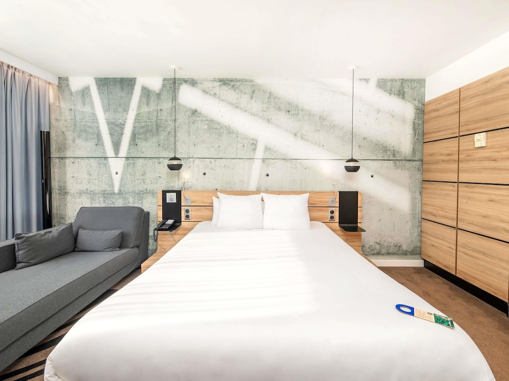 Suite Superior con cama grande, sofá y cocina del hotel Novotel Krakow City West. Foto 4