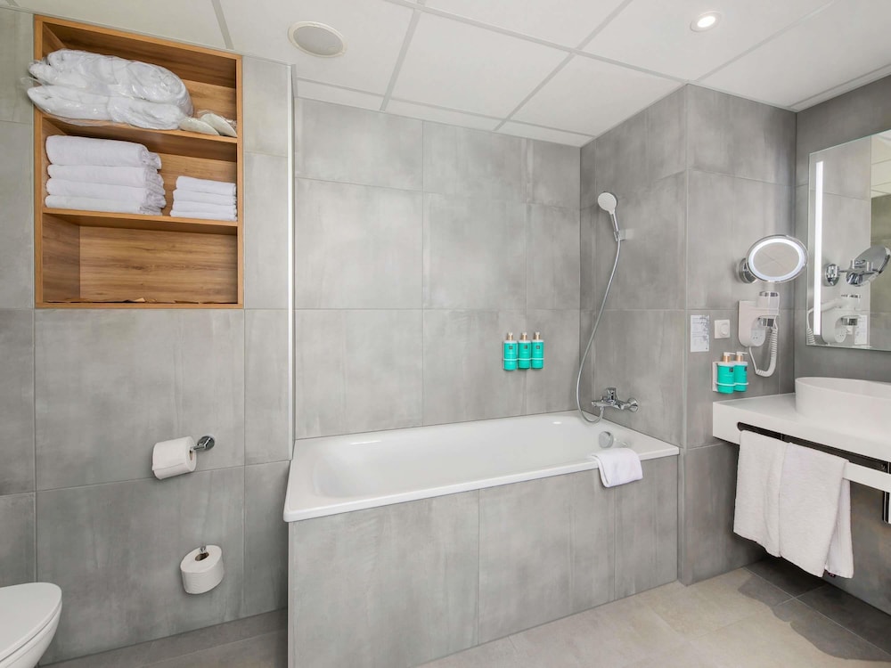 Suite Superior con cama grande, sofá y cocina del hotel Novotel Krakow City West. Foto 5