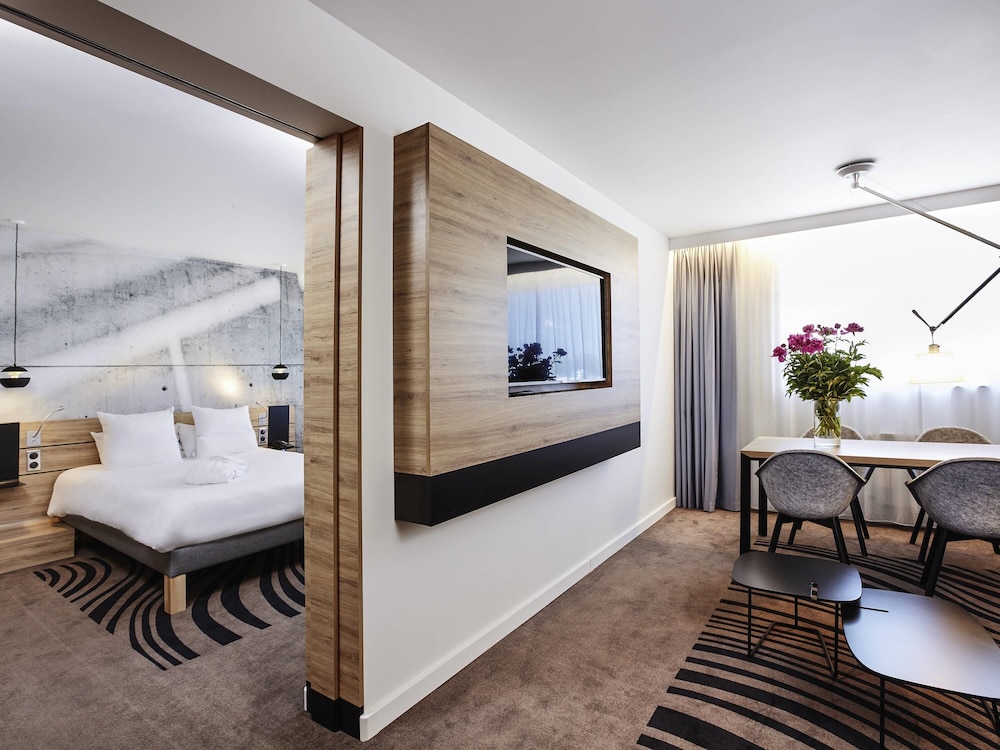 Suite Superior con cama grande, sofá y cocina del hotel Novotel Krakow City West. Foto 6