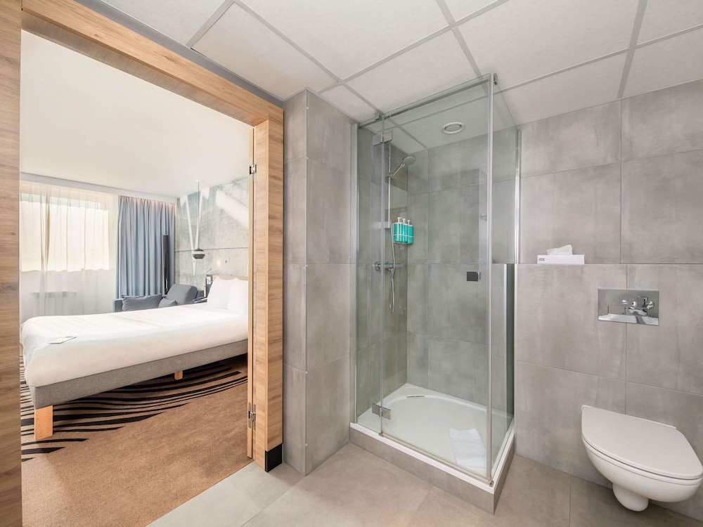 Suite Superior con cama grande, sofá y cocina del hotel Novotel Krakow City West. Foto 8