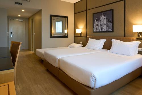 Habitación estándar con 2 camas individuales y cama supletoria del hotel Portus Cale. Foto 1