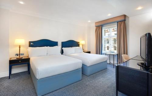 Habitación con dos camas dobles del hotel The Waldorf Hilton, London. Foto 4