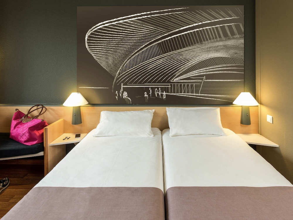 Habitación con una cama doble o dos camas individuales y un sofá cama del hotel Ibis Liège Seraing. Foto 11