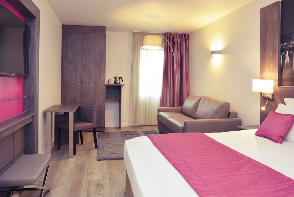 Habitación Superior con cama doble y sofá del hotel Mercure Lyon Est Chaponnay. Foto 1