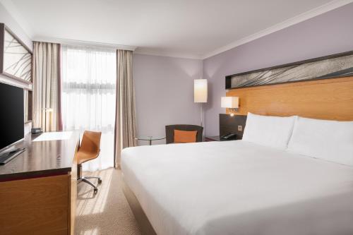 Habitación con cama grande y cama supletoria del hotel Hilton London Kensington