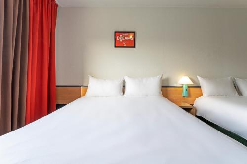 Habitación Doble Estándar con 2 camas dobles del hotel Ibis Paris Pantin Eglise. Foto 7