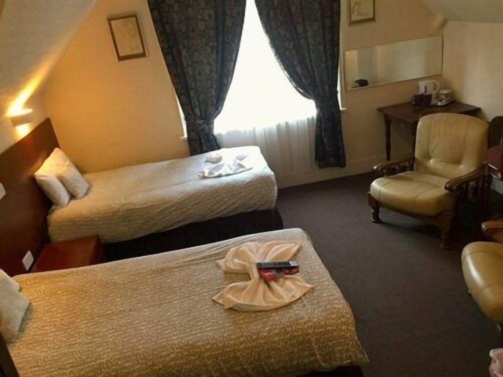 Habitación con 2 camas individuales, baño privado del hotel Charlotte Guest House. Foto 1