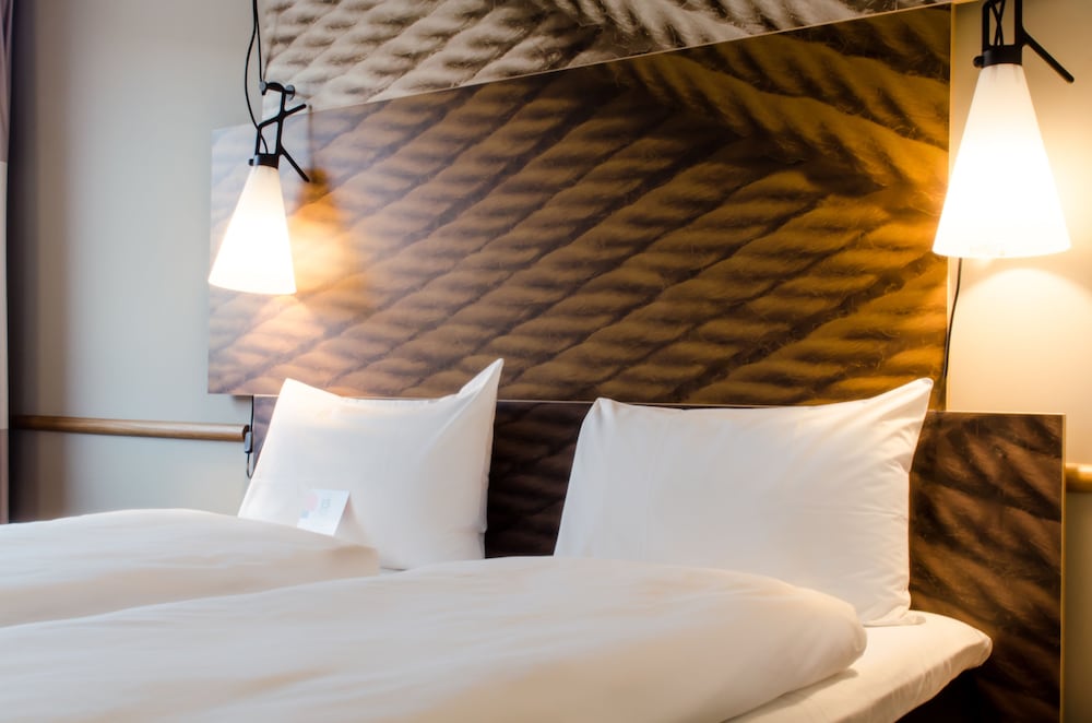 Habitación con 2 camas individuales equipada con la nueva ropa de cama del hotel Ibis Muenchen City Arnulfpark. Foto 1