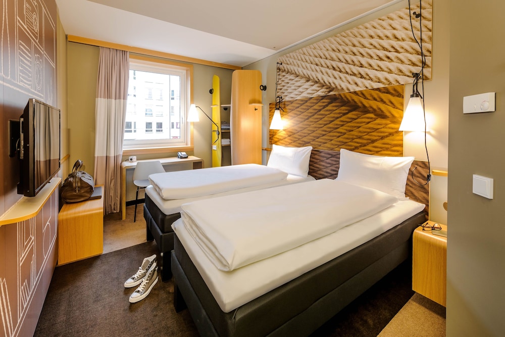 Habitación con 2 camas individuales equipada con la nueva ropa de cama del hotel Ibis Muenchen City Arnulfpark. Foto 2