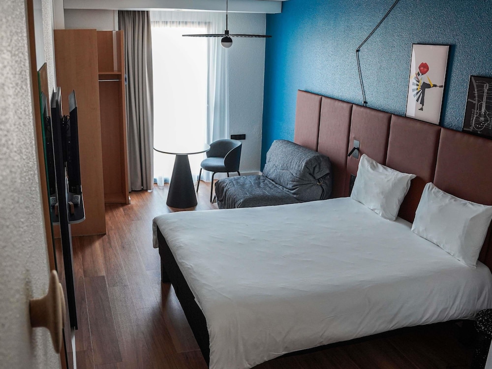 Habitación con 1 cama doble y 1 sofá - cama individual del hotel Ibis Bayeux Port En Bessin. Foto 6