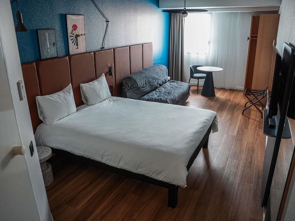 Habitación con una cama doble y sofá - cama doble del hotel Ibis Bayeux Port En Bessin