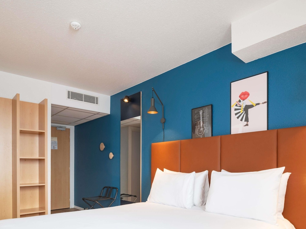 Habitación con una cama doble y camas individuales del hotel Ibis Bayeux Port En Bessin