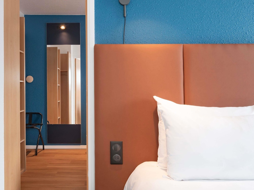 Habitación con una cama doble y camas individuales del hotel Ibis Bayeux Port En Bessin. Foto 1