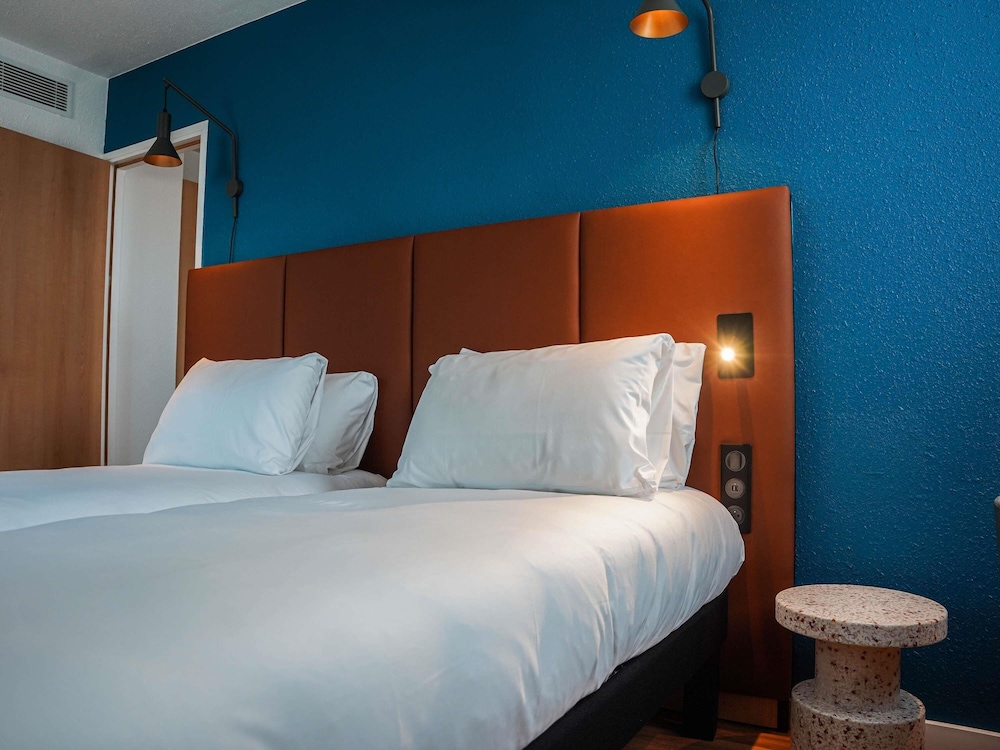 Habitación con una cama doble y camas individuales del hotel Ibis Bayeux Port En Bessin. Foto 6