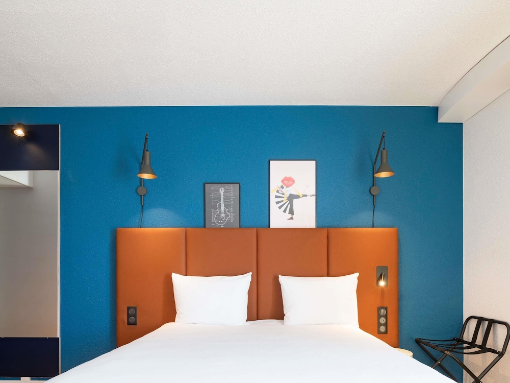 Habitación con una cama doble y camas individuales del hotel Ibis Bayeux Port En Bessin. Foto 9