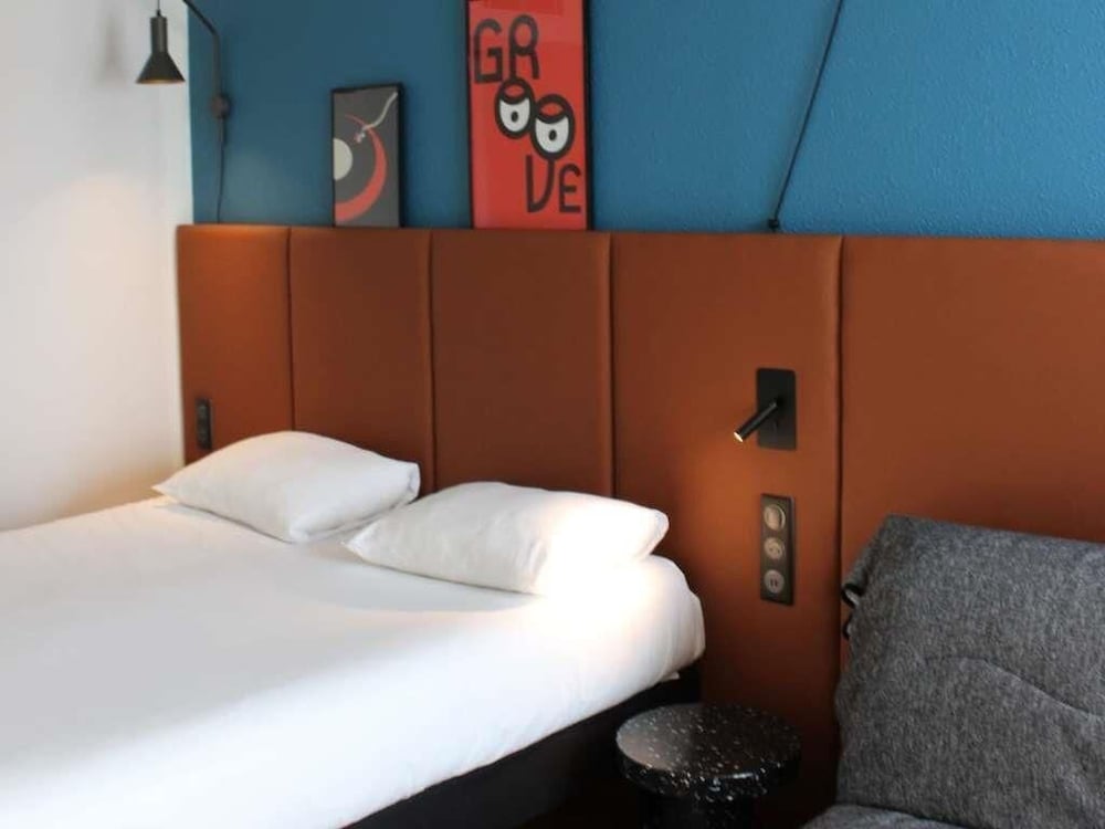 Habitación con una cama doble y camas individuales del hotel Ibis Bayeux Port En Bessin. Foto 10