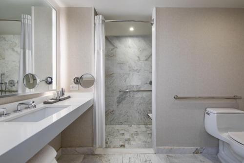 Suite Junior adaptada para personas con movilidad reducida y equipada con sofá cama y ducha accesible en silla de ruedas - Cama extragrande del hotel Jw Marriott Essex House New York