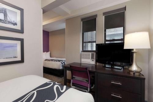 Un dormitorio con dos camas individuales y un dormitorio completo del hotel La Quinta by Wyndham New York City Central Park. Foto 4