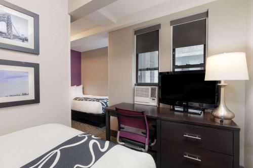 Un dormitorio con dos camas individuales y un dormitorio completo del hotel La Quinta by Wyndham New York City Central Park. Foto 5