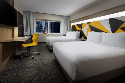 Habitación Social Deluxe con 2 camas dobles y vistas a Times Square del hotel M Social Times Square New York. Foto 4