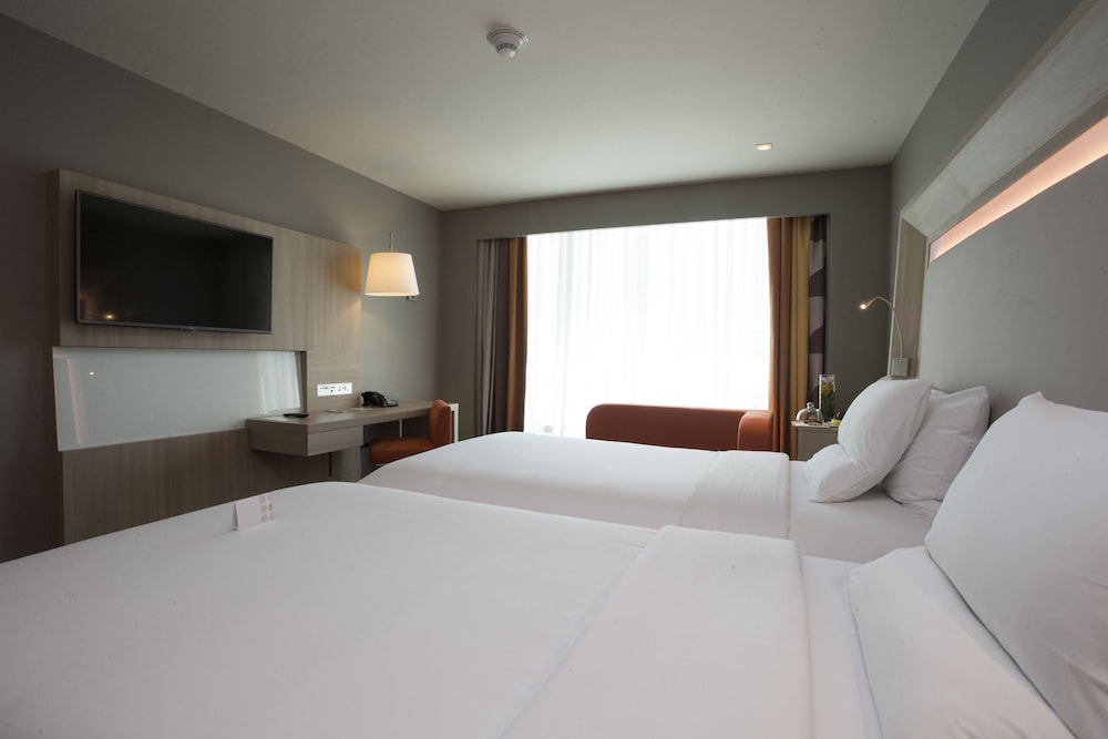 Habitación Deluxe con dos camas individuales del hotel Novotel Manila Araneta City. Foto 4