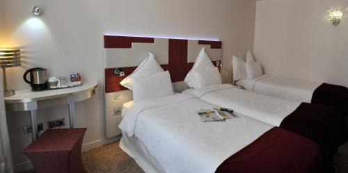 Habitación Doble Superior con 2 camas individuales y sofá cama del hotel Mercure Paris Opéra Faubourg Montmartre. Foto 4