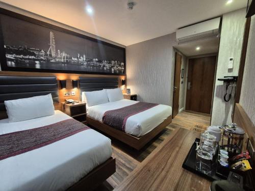 Habitación Triple Clásica con baño del hotel London Court. Foto 1