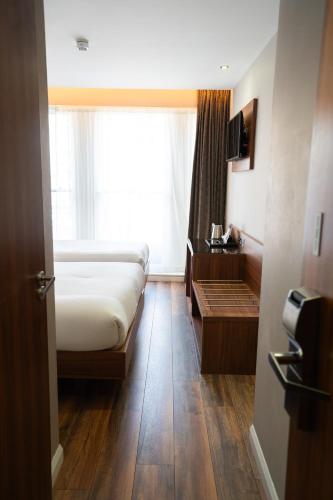 Habitación Triple Clásica con baño del hotel London Court. Foto 23