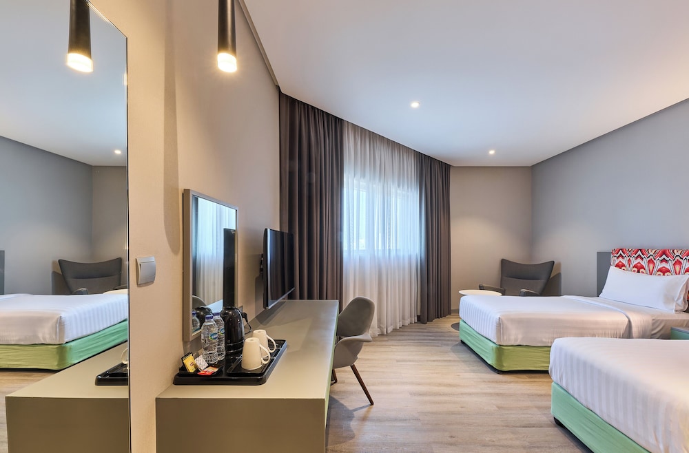 Suite con dos camas individuales separadas y salón del hotel Ibis Styles Dubai Jumeira
