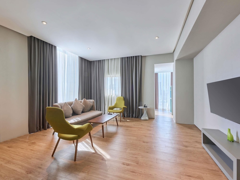 Suite con dos camas individuales separadas y salón del hotel Ibis Styles Dubai Jumeira. Foto 1