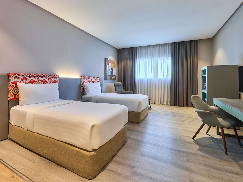 Suite con dos camas individuales separadas y salón del hotel Ibis Styles Dubai Jumeira. Foto 2