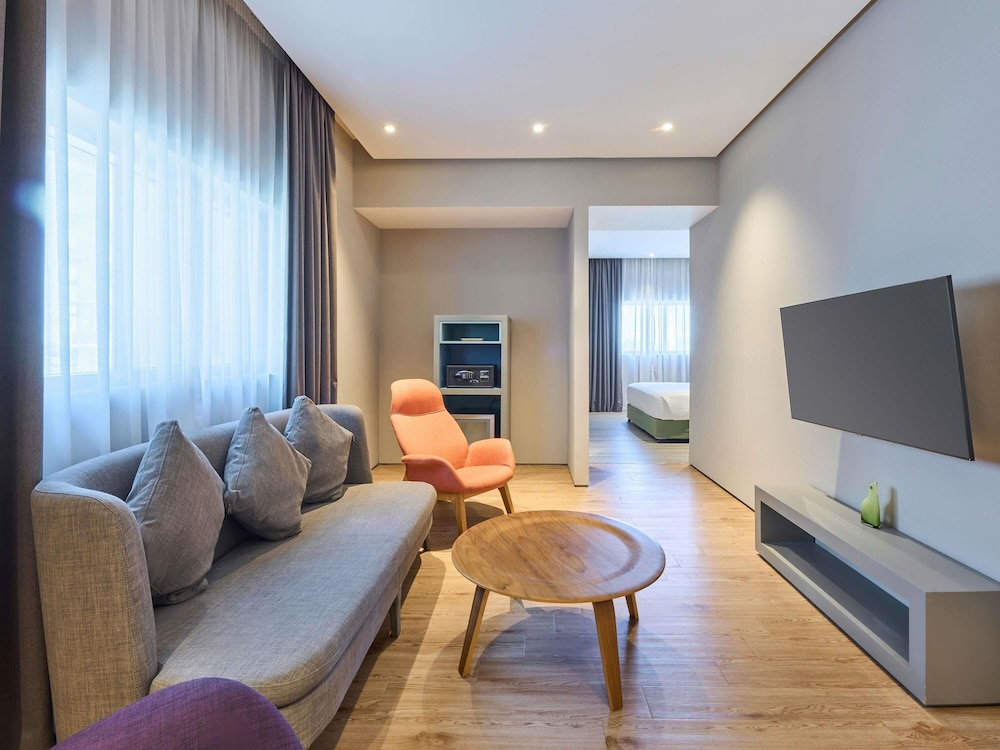 Suite con cama doble y salón del hotel Ibis Styles Dubai Jumeira