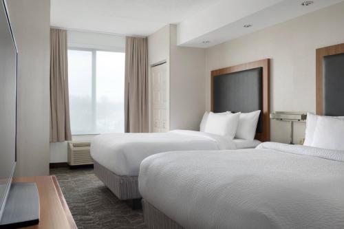 Habitación adaptada para personas con movilidad reducida/discapacidad auditiva con ducha accesible en silla de ruedas - Cama extragrande del hotel Springhill Suites By Marriott Syracuse Carrier Circle