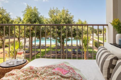 Habitación Deluxe con cama extragrande, balcón y vistas a la piscina del hotel Victoria Golf Resort and Spa Managed by Accor