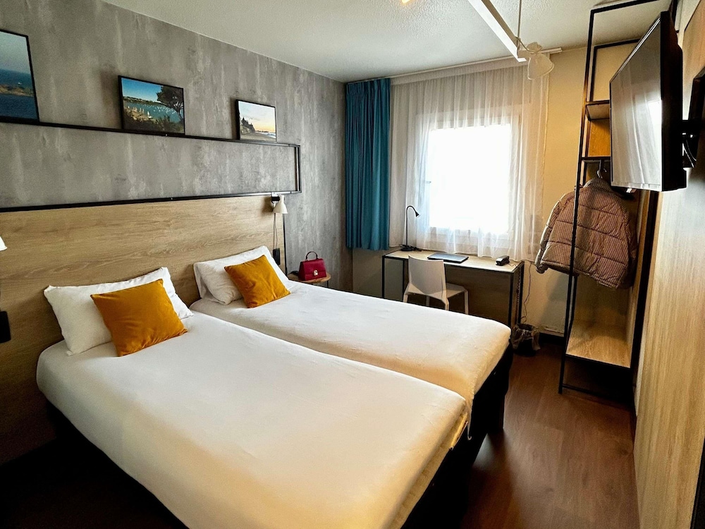 Habitación con dos camas individuales equipada con nueva ropa de cama del hotel Ibis Saint Malo La Madeleine