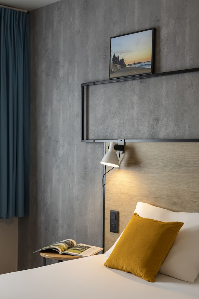 Habitación con dos camas individuales equipada con nueva ropa de cama del hotel Ibis Saint Malo La Madeleine. Foto 1