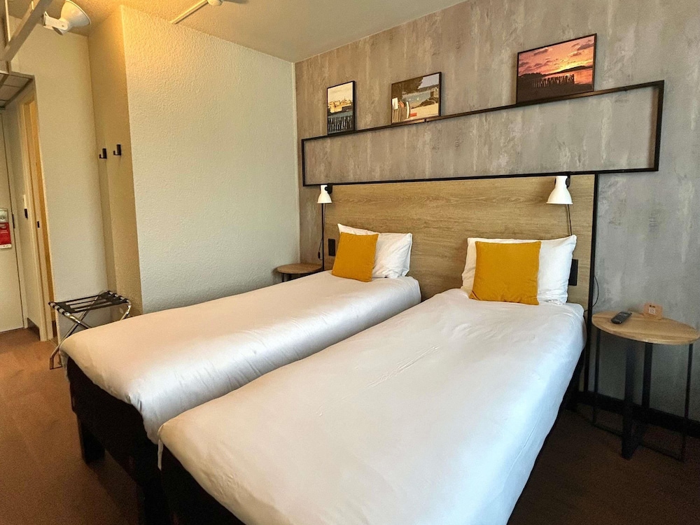 Habitación con dos camas individuales equipada con nueva ropa de cama del hotel Ibis Saint Malo La Madeleine. Foto 10