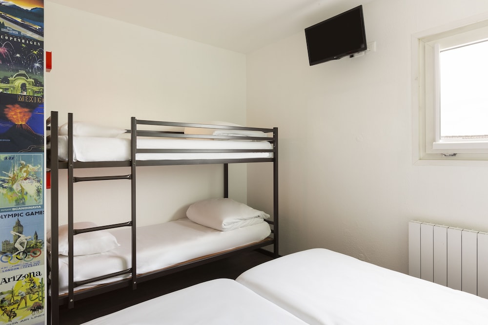Habitación con 4 camas individuales y baño del hotel F1 Reims Tinqueux. Foto 1