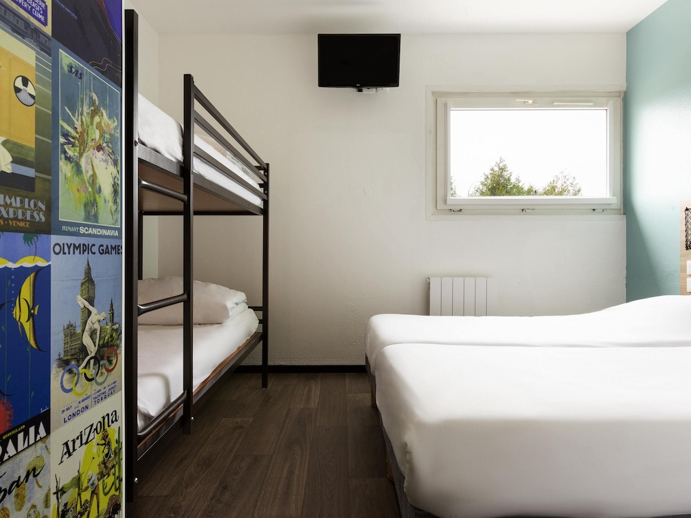 Habitación con 4 camas individuales y baño del hotel F1 Reims Tinqueux. Foto 3