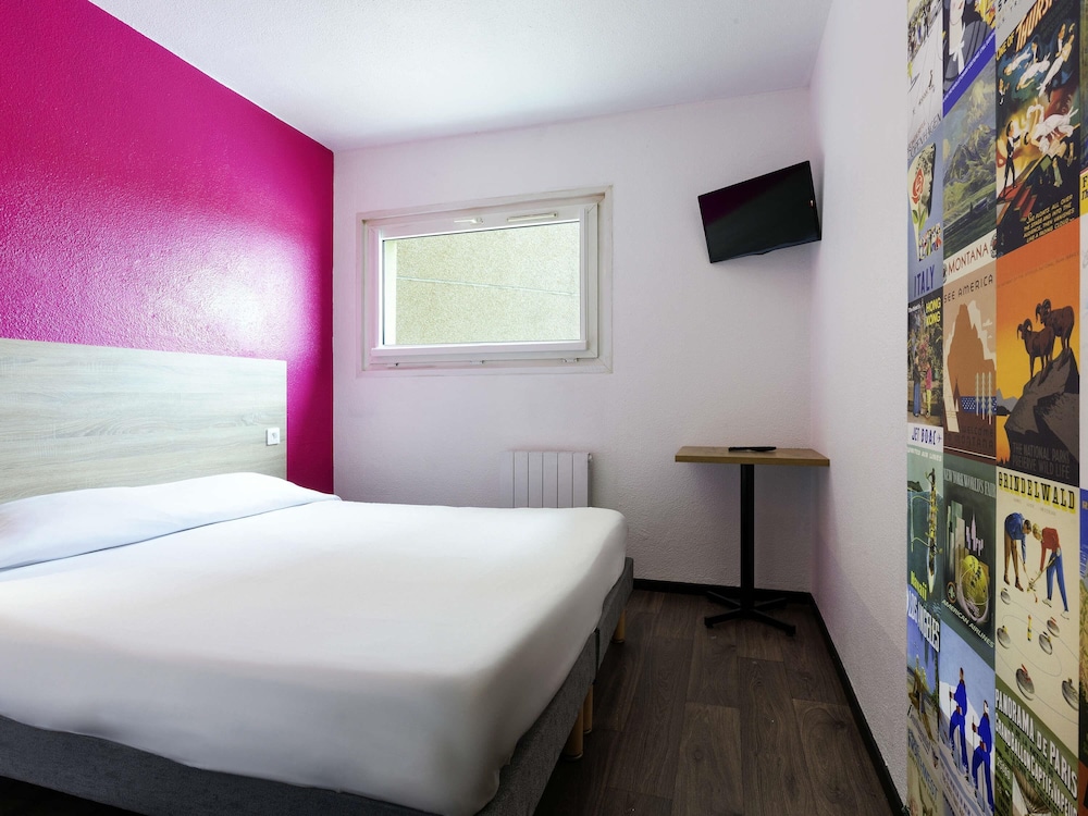 Habitación con una cama doble y baño del hotel F1 Reims Tinqueux